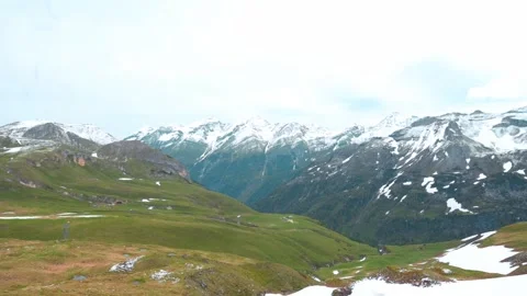 A breathtaking panoramic view of snow-capped mountains and lush green valleys in Stockbeeldmateriaal 282691440