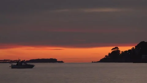 Breathtaking sunset over calm ocean waters with silhouette of small motorbo.. Vidéo 335615200