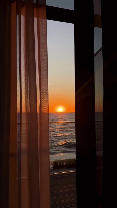 Breathtaking sunset over ocean, seen through window with sheer curtains. Stock Footage 305402412