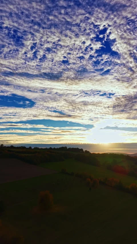 Breathtaking sunset over rolling hills, with vibrant clouds painting the evening Stock Footage 331401856