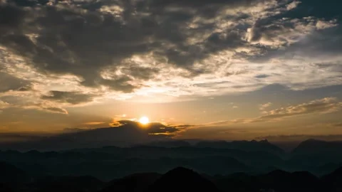 Breathtaking Sunset Over Silhouetted Mountain Ridges and Rolling Hills at Dusk Stock Footage 342209588