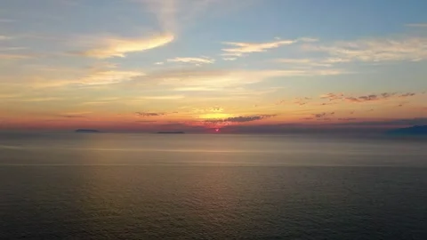 Breathtaking sunset over a tranquil ocean with distant island silhouette. Stock Footage 295003033