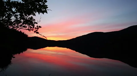 BREATHTAKING SUNSET REFLECTED ON CALM LAKE SURFACE ORANGE PINK Stock Footage 52028653