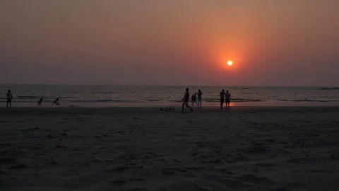 Breathtaking sunset at a wide beach with activity of walk, stroll, yoga Stock Footage 106067590