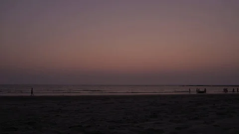 Breathtaking sunset at a wide beach with activity of walk, stroll, yoga Stock Footage 106067945