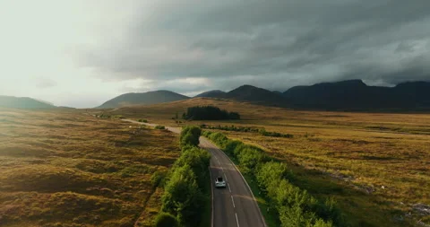 Breathtaking view from above of white car moving on NC500 in sunny Scottish Vídeo Stock 288014155