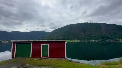 A breathtaking view of a calm lake reflecting the surrounding mountains 스톡 동영상 314112704