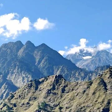 Breathtaking view of distant glacier-capped mountain summit under bright blue su Stock Photos