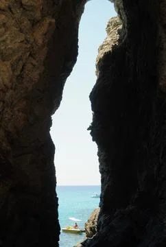 A breathtaking view of the endless sea opens up through the dark grotto. Stock-Fotos