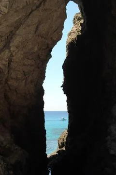 A breathtaking view of the endless sea opens up through the dark grotto. Stock-Fotos