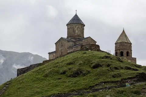 Breathtaking view of a mountain range with a ancient Gergeti Trinity Church.. Stock Photos