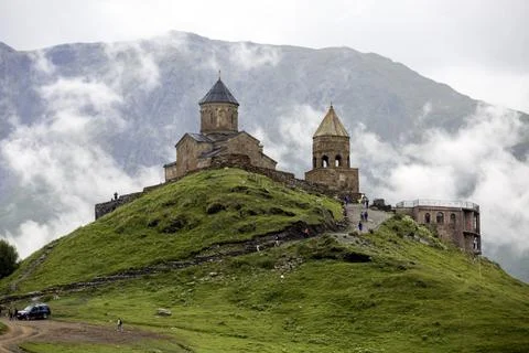 Breathtaking view of a mountain range with a ancient Gergeti Trinity Church.. Stock Photos