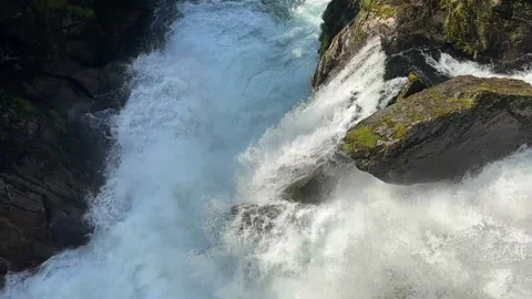 A breathtaking view of a powerful waterfall surrounded by lush greenery 動画素材 313952930