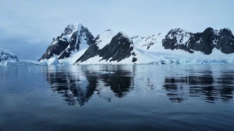 Breathtaking view of a snow-covered mountain range under a partly cloudy sky. Stock Footage 297846179
