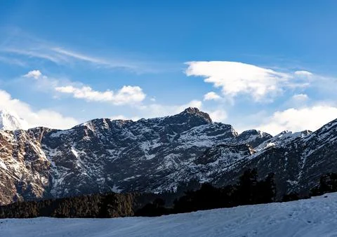 Breathtaking view of snowcap mountain range with bright sky 库存照片