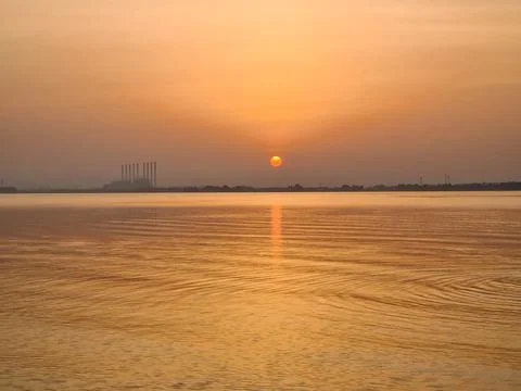 Breathtaking view of sunset or dawn and sea water in foreground Stock Photos