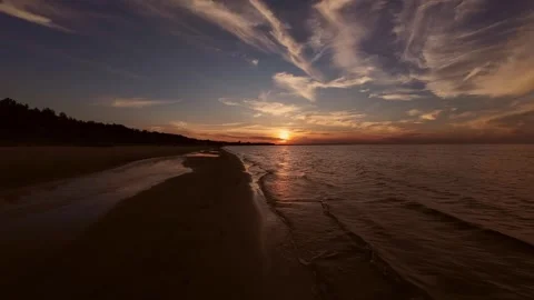 A breathtaking view of a sunset over a serene beach, with soft waves and a sky Видео 282691508