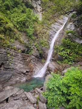 A breathtaking view of a waterfall in a natural setting, surrounded by rocks  Stock Photos