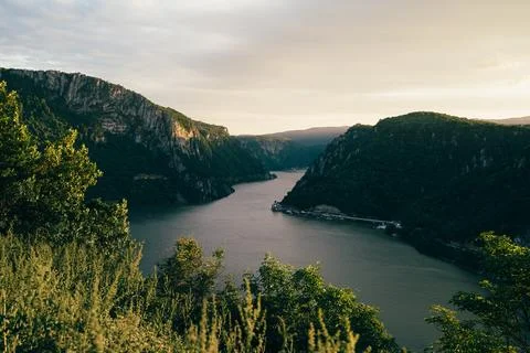 A breathtaking view of the winding river surrounded by lush hills during go.. Stock Photos