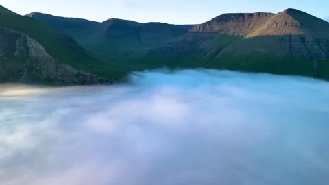 Breathtaking views of Drangarnir cliffs rising above the clouds in the Faroe Stock Footage 316221155