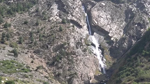 Breathtaking waterfall cascading down rugged rocky mountain landscape Video stock 330317271