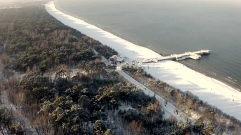 Breathtaking Winter Flight Above A Sandy Beach With Pier Full Of Walking People Video stock 150043368