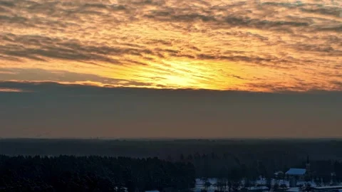 A breathtaking winter timelapse capturing a vibrant golden sunset over a snowy Stock Footage 333531364