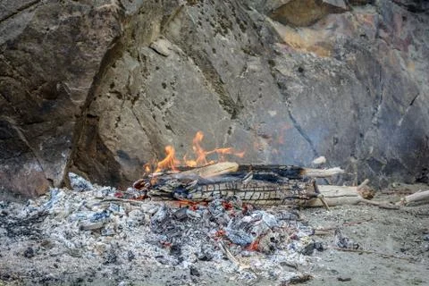 Breeding a fire on an old ashes on a sandy beach in the mountains Foto stock