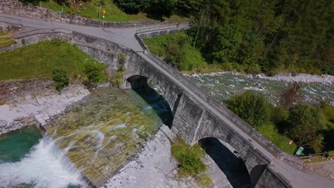Bregaglia stone bridge spanning alpine river Switzerland. Aerial 스톡 동영상 334100751
