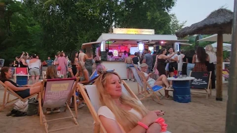 Bregenz, Austria - 19 August 2023: Beach‑style evening bar with sand seating Stock Footage 339075407