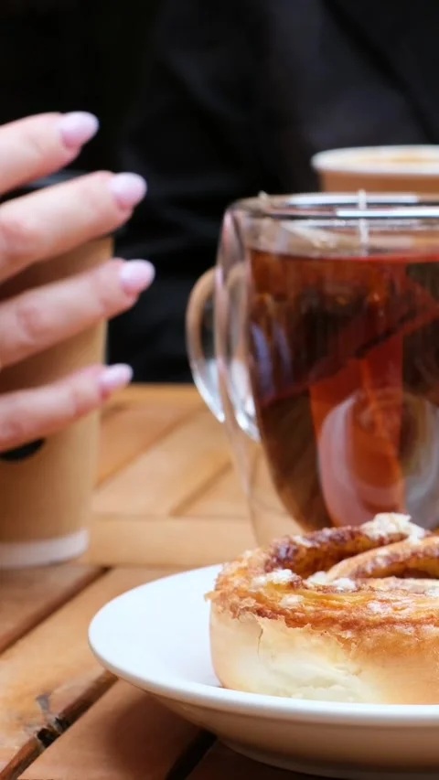 Brew a bag of black leaf tea in a clear mug with hot water. Warm up on a cool Stock Footage 318067636