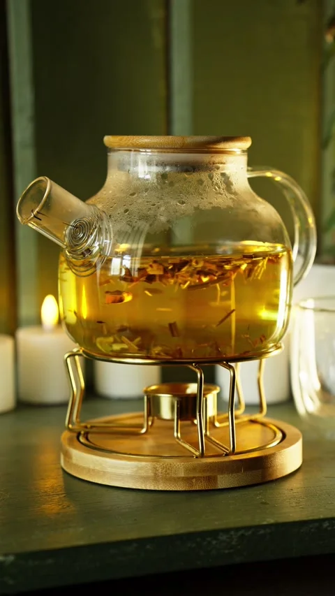 Brew herbal tea with stylish teapot in cozy kitchen at evening. Elegant teapot Video stock 292367582