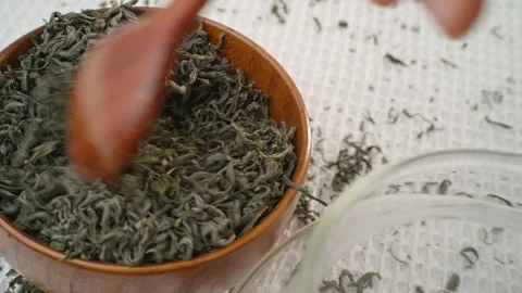 To brew, remove the leaves of green tea from the cup with a spoon. Stock Footage 295046720