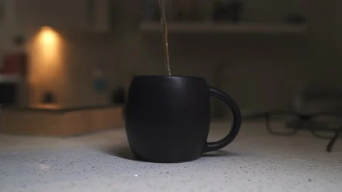 Brew tea, hot water in a black cup, steam comes Video stock 124400944