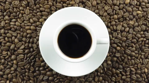 Brewed Black Coffee On A Background Of Rotating Coffee Beans. Video stock 196087986