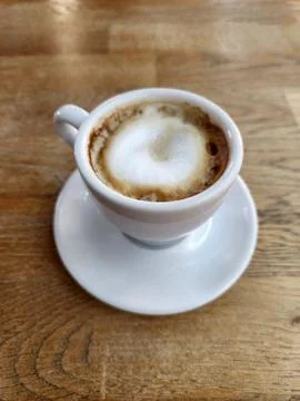 Brewed coffee in a white cup. White cup with coffee on a wooden table Stock Photos