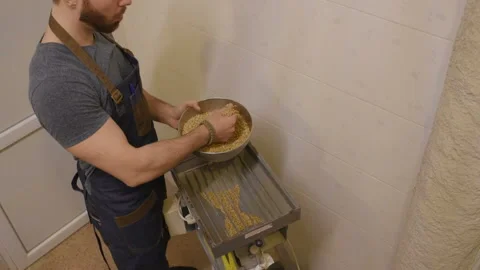 Brewer with malt on the background of the brewery Stock Footage 99983089