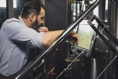 Brewer working with technological equipment Stock Photos