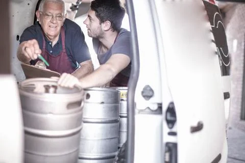 Brewers loading kegs into back of van Stockfoto's
