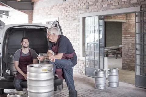Brewers loading kegs into back of van Stockfoto's