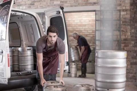 Brewers loading kegs into back of van Stockfoto's