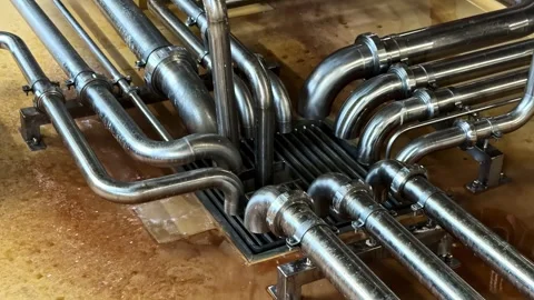 Brewery industrial pipeline system draining fresh craft beer into floor drain Stock Footage 341544141
