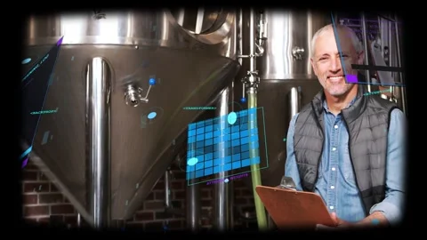 Brewery technician reading clipboard and initiating HUD, inspecting tanks and Stock Footage 334040595