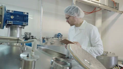 Brewery Worker Takes Sample Of Produced Wort Beer Ingredient With Measuring Cup Stock Footage 196292305