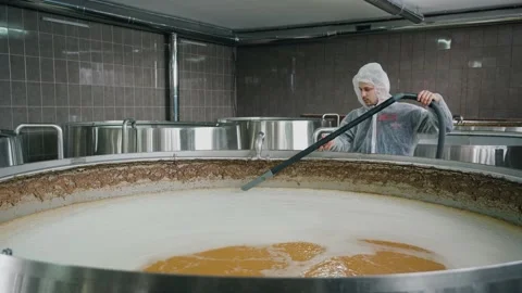 A brewery worker uses a vacuum cleaner to collect foam from beer that is brewed  Vidéo 237198789