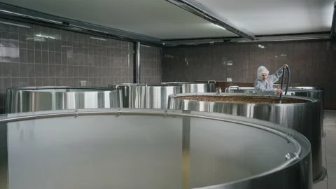 A brewery worker uses a vacuum cleaner to collect foam from beer that is brewed  Vidéo 237198861