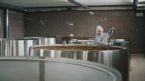 A brewery worker uses a vacuum cleaner to collect foam from beer that is brewed  Vidéo 237198900