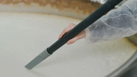 A brewery worker uses a vacuum cleaner to collect foam from beer that is brewed  Vidéo 237198923