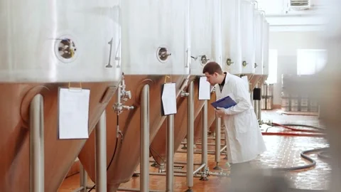 Brewery worker in a white coat supervises the work Stock Footage 158265243