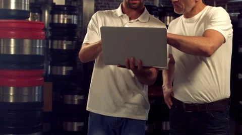 Brewery workers checking info on a laptop Stock Footage 59689333